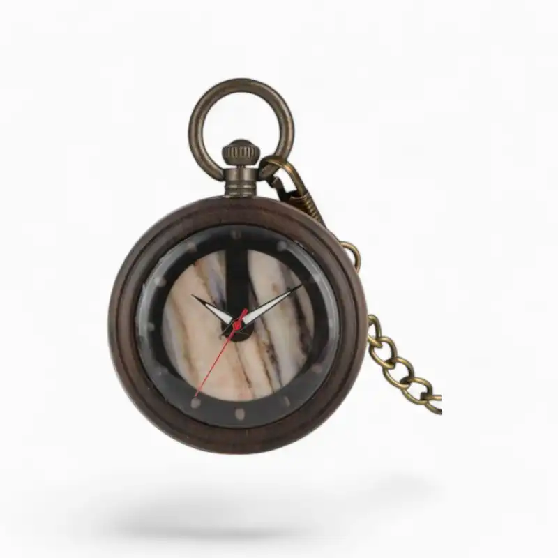 Montre à gousset vintage avec cadran en marbre, aiguilles noires et rouges et chaîne en bronze, isolée sur fond blanc.