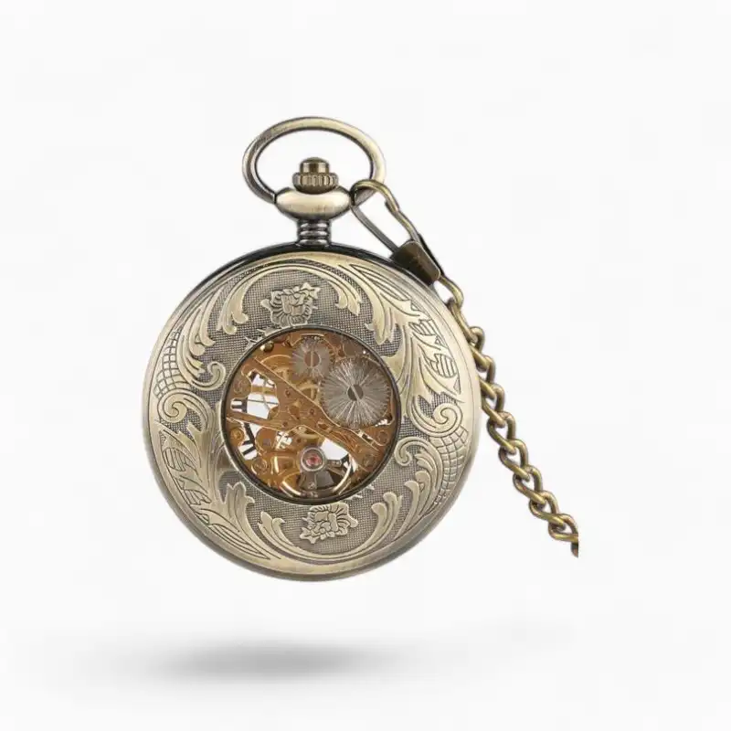 Montre à gousset mécanique avec motif de fleur de lys gravé, cadran ouvert et rouages visibles, finition or vintage et chaîne assortie.
