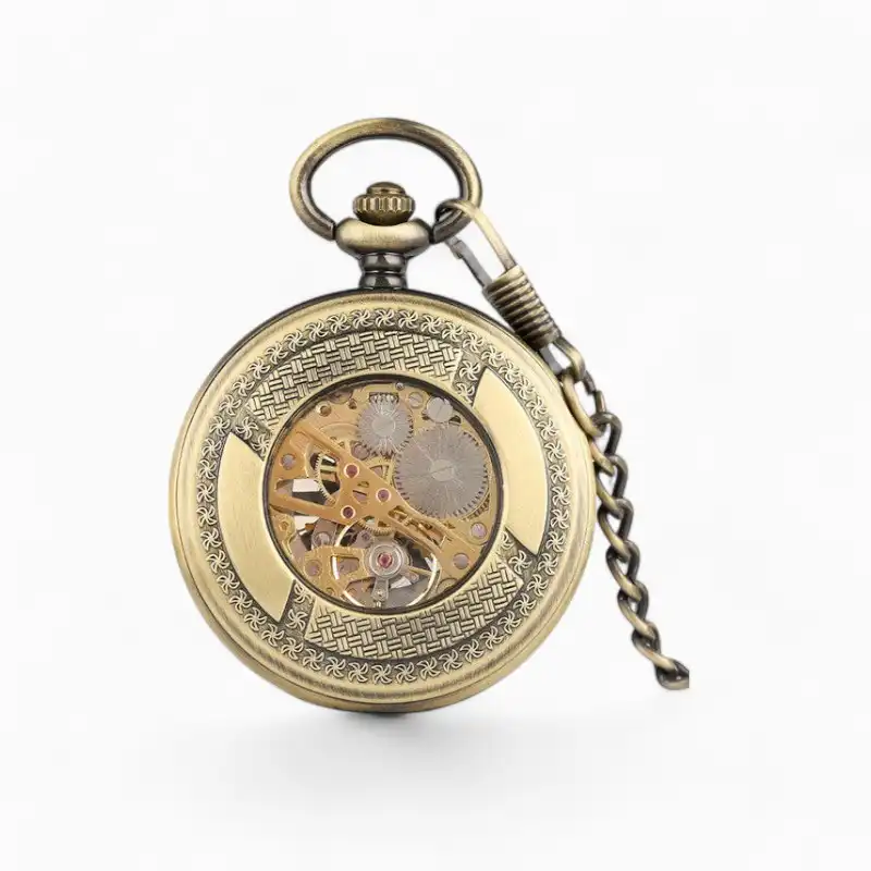 Montre à gousset mécanique dorée avec visibilité des engrenages et de la roue, accompagnée de sa chaîne, sur fond blanc.
