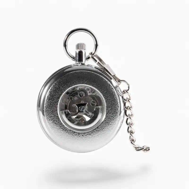 Montre à Gousset Mécanique Vintage Argentée sur fond blanc, affichage de l'engrenage interne à travers une fenêtre transparente, design classique avec chaîne en métal.