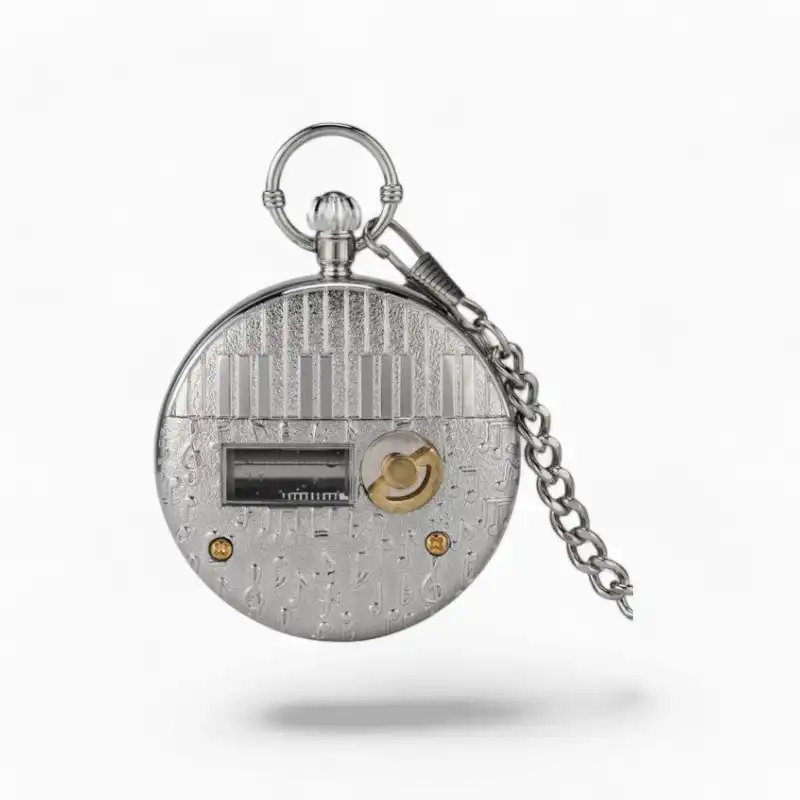 Montre à gousset musicale avec mécanisme visible évoquant "Le lac des cygnes", finition argentée et détails musicaux gravés, accompagnée de sa chaîne.