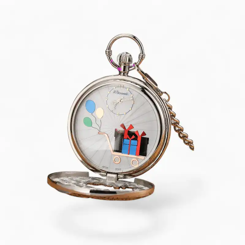 Montre à gousset musicale Joyeux Anniversaire argentée ouverte, affichage analogique avec motifs de ballons et cadeau, chaînette en métal, sur fond de partitions et livres anciens.