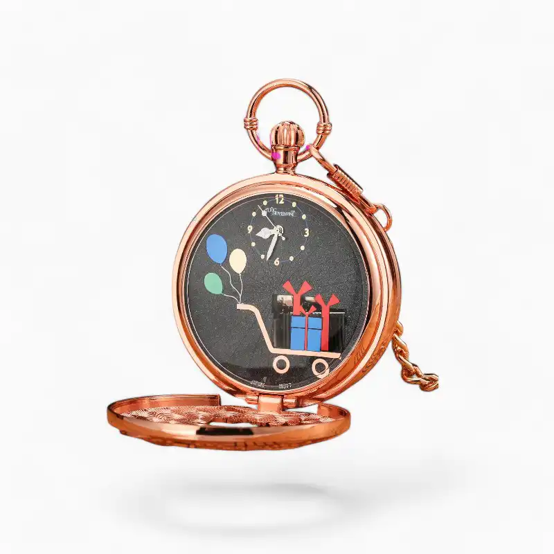 Montre à gousset musicale "Joyeux Anniversaire" en métal cuivré avec cadran noir affichant des ballons et des notes de musique, posée sur fond de livres anciens et partitions.